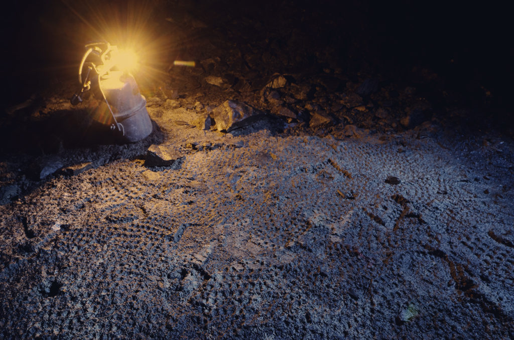 ©Raphaël Charuel - À la lueur d'une lampe à flamme se révèlent les empreintes des pas des ouvriers.